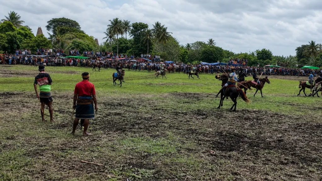 Vue d'ensemble de la Pasola de Ratenggaro avec les cavaliers en action et la foule à Sumba